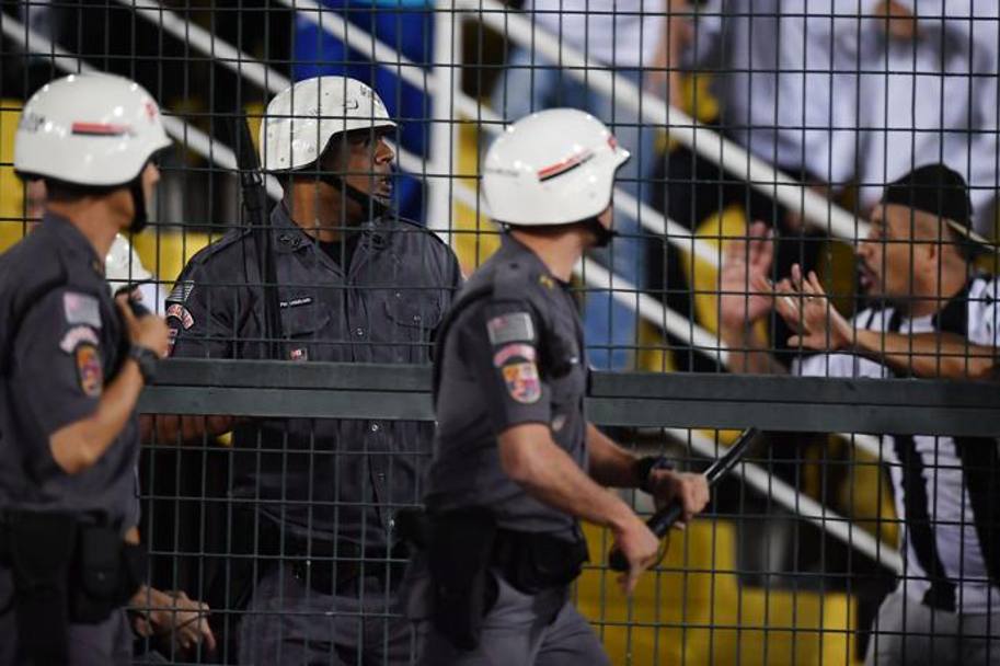 Un tifoso del Santos discute con un gruppo di poliziotti. AFP
